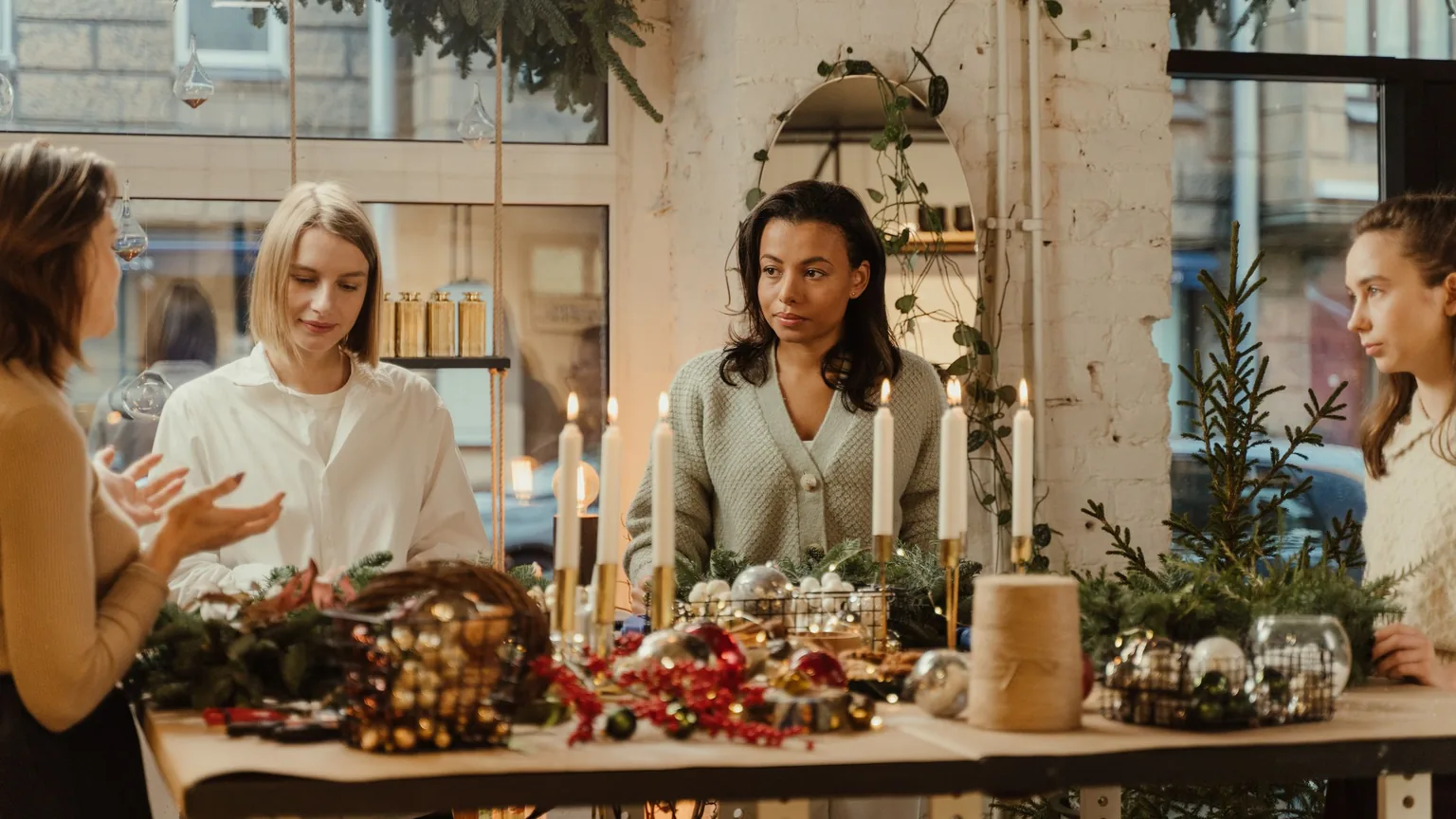 Members of a creative collective gathered around a long workshop table, making things together