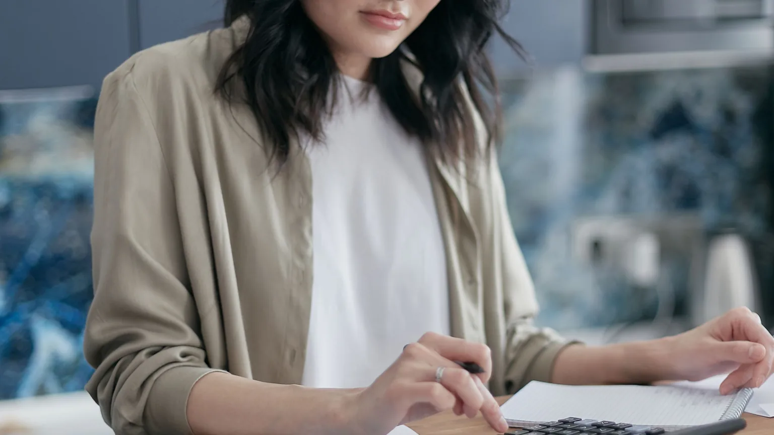 A treasurer working through bills with a calculator and a stack of receipts