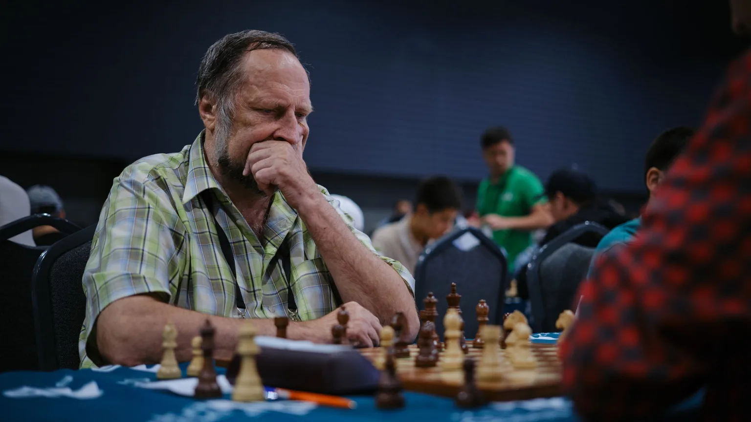 A player deep in thought mid-game at a club chess tournament