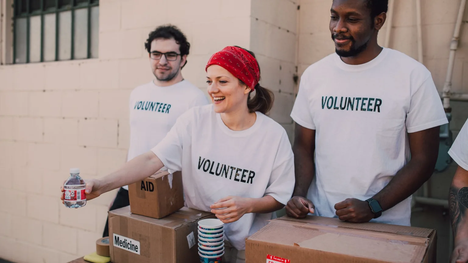 Volunteers in matching shirts handing out goods at a donation table