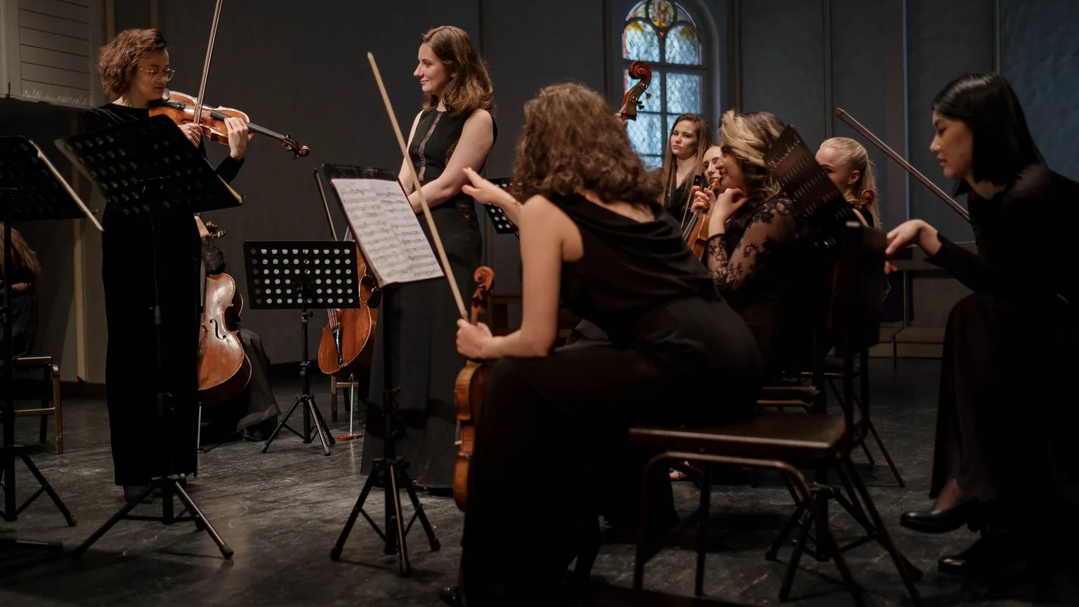 An orchestra in rehearsal, with music stands and string players