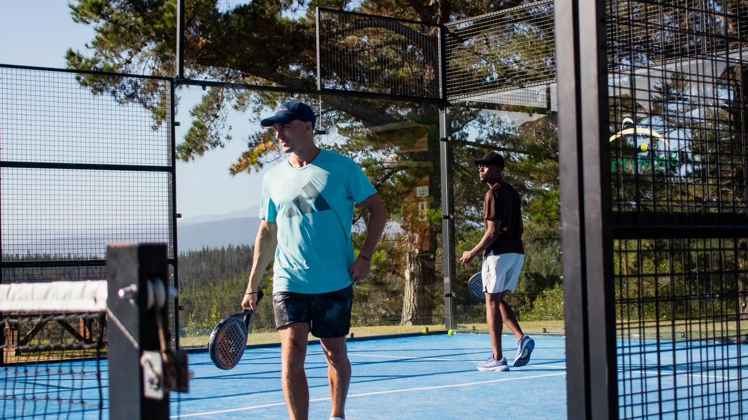 Padel players tapping rackets over the net before a game