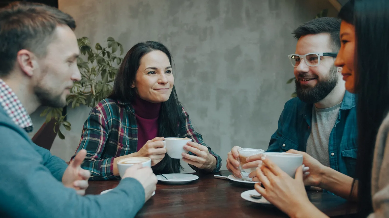 Friends talking over coffee at a cafe table