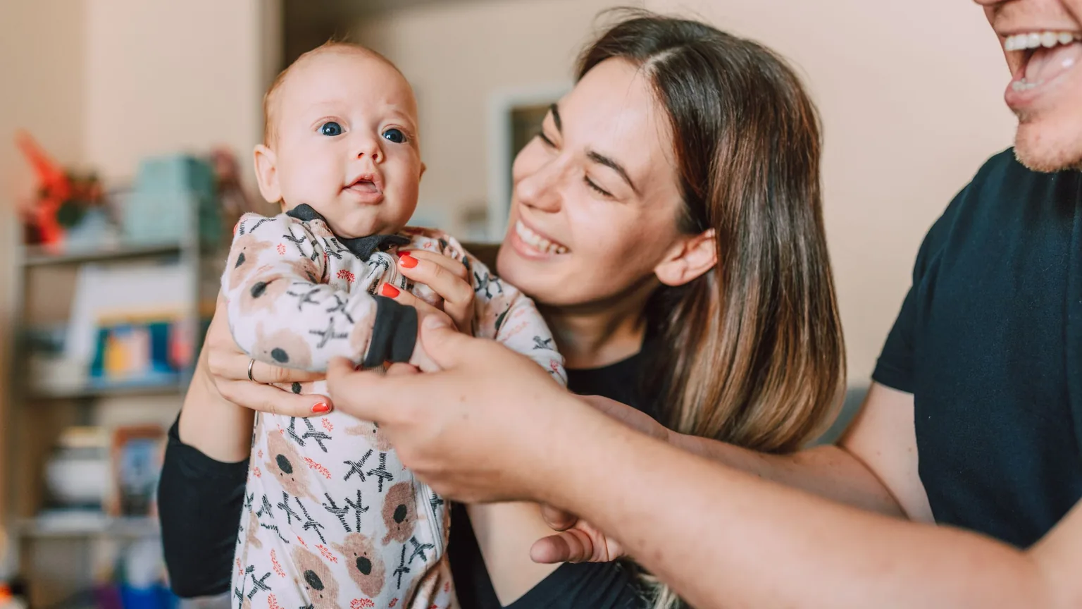 Parents smiling with their baby at home