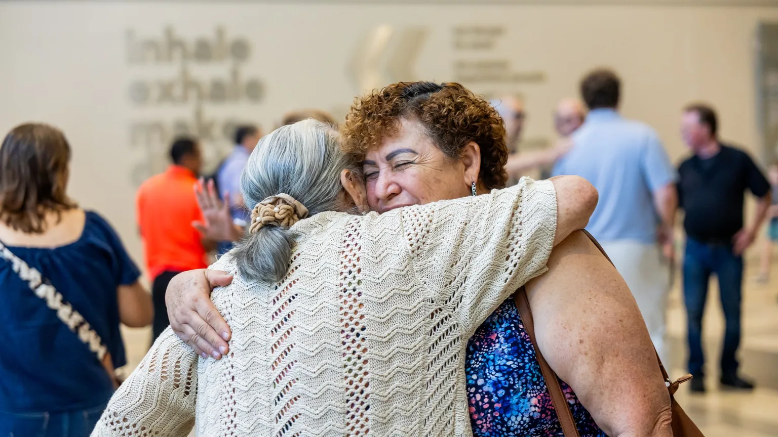 Two women hugging as one returns to a gathering