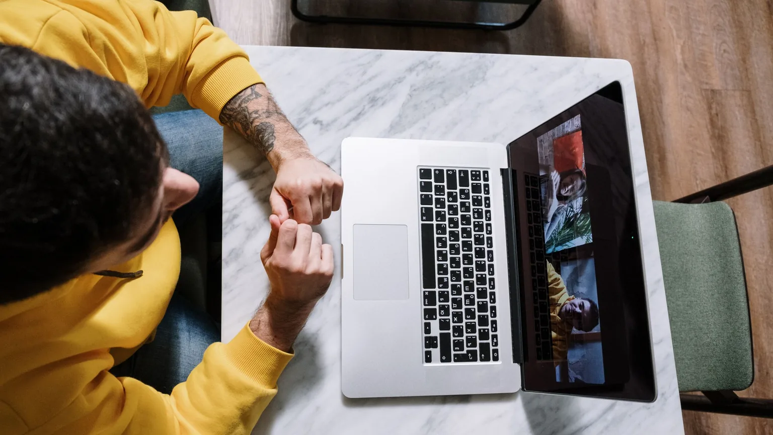 A member at home on a laptop group video call, seen from above