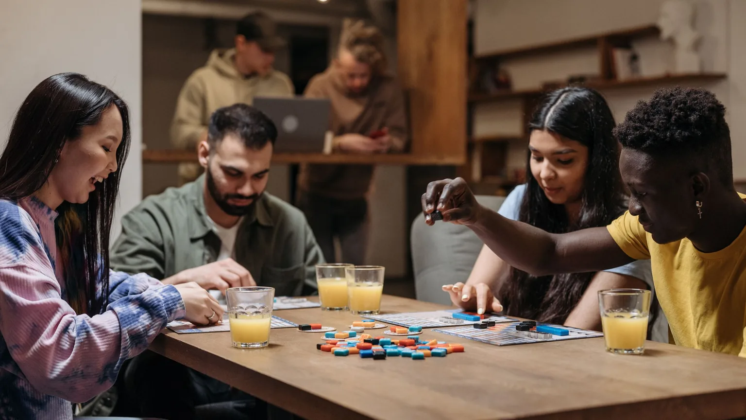 A board-game night in a cafe, with a laptop open on the next table
