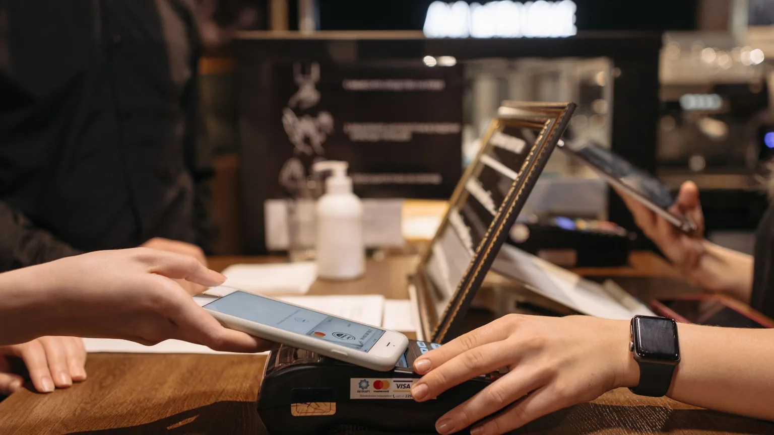A phone being tapped on a card terminal to pay