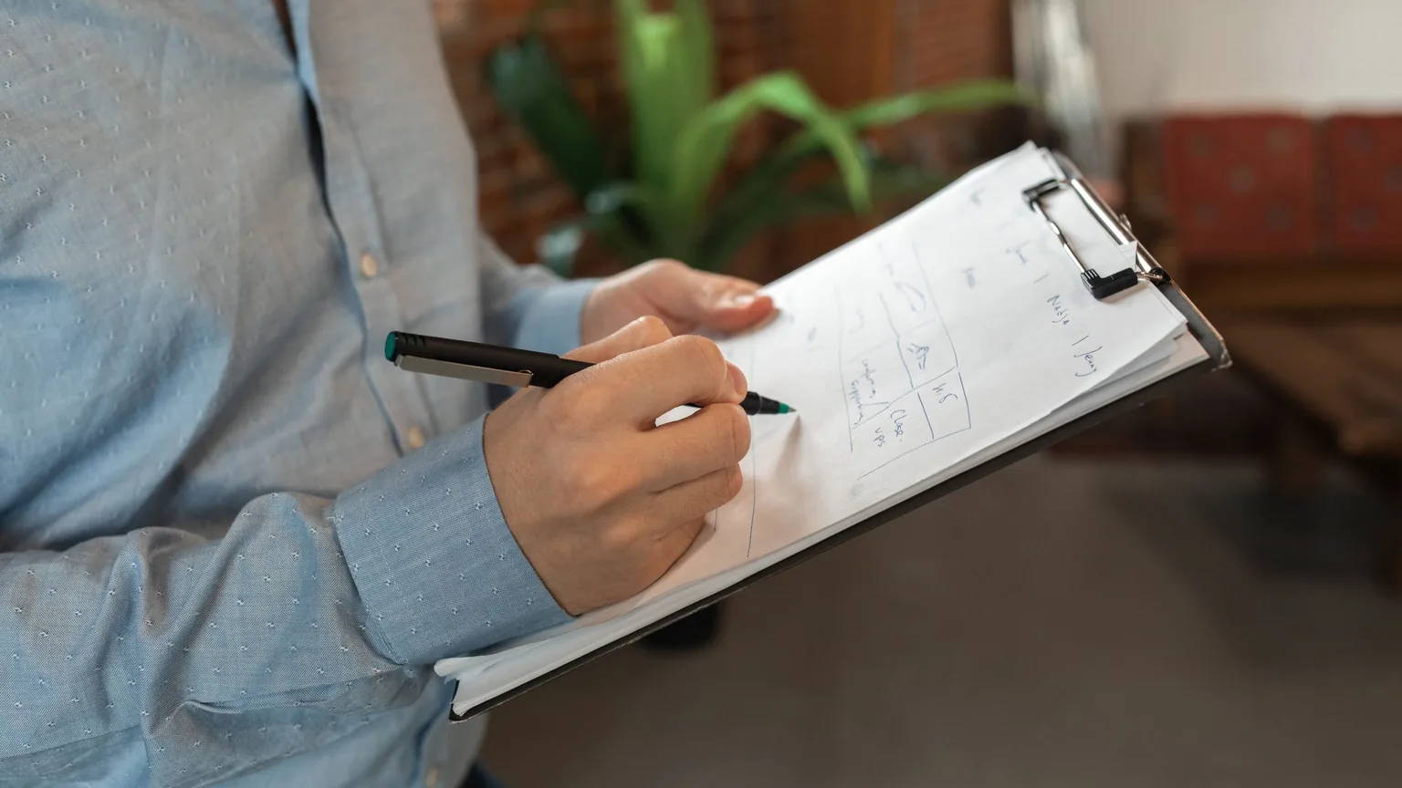 A volunteer with a clipboard checking names off a list at the door