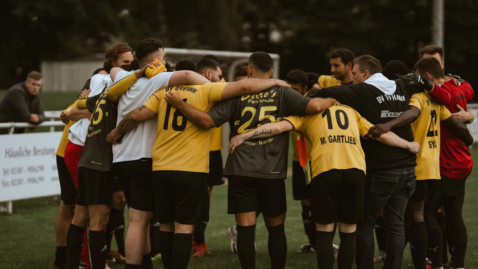 An amateur football team in a huddle before a match