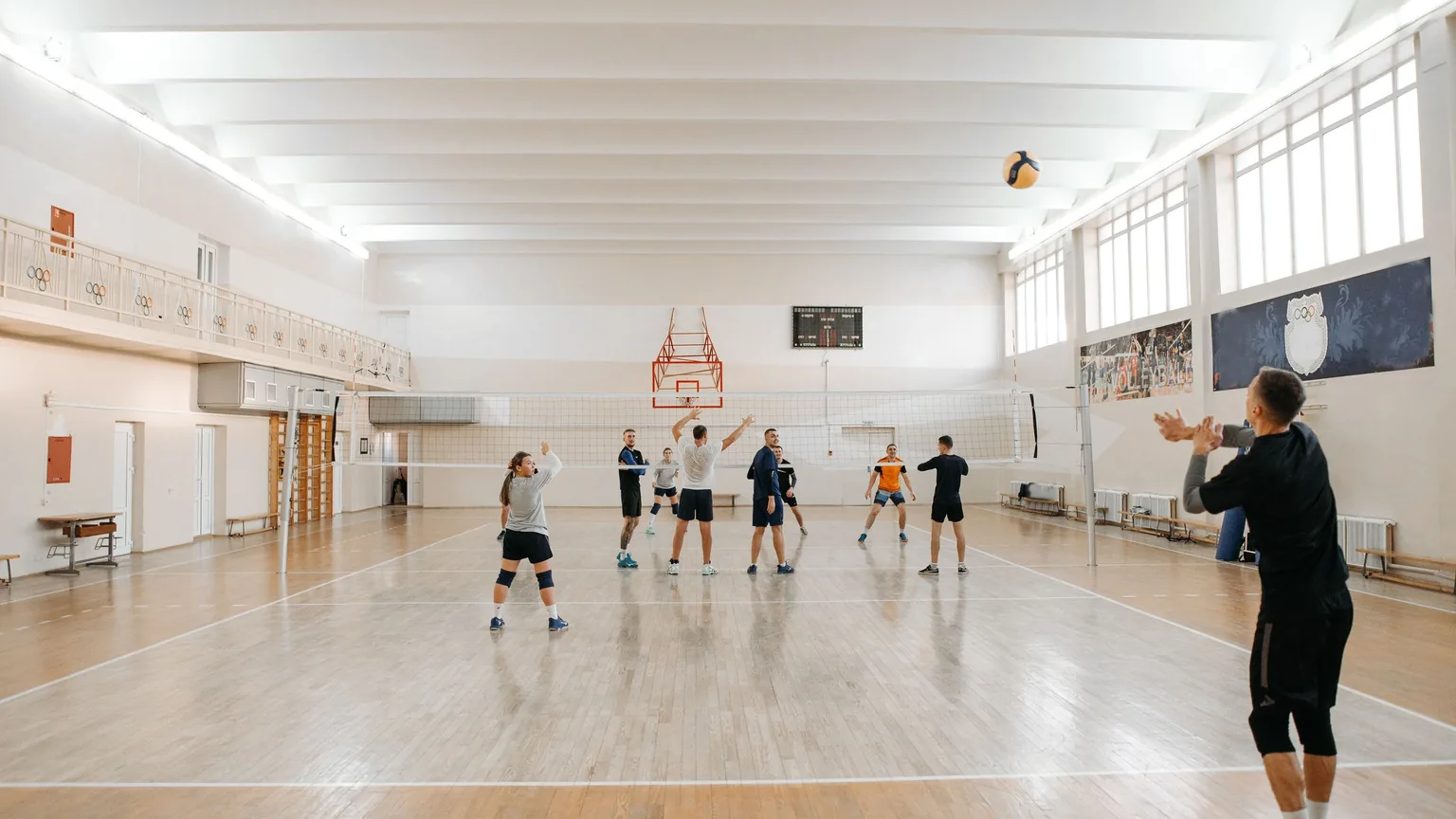 Volleyball players warming up in a community sports hall