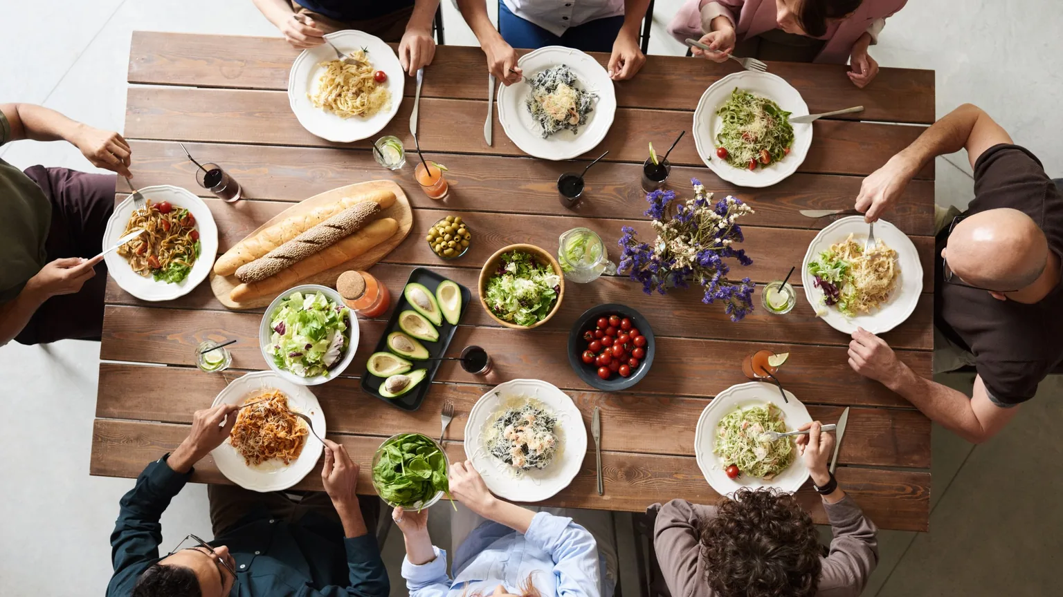 A group sharing a meal around one long table, seen from above