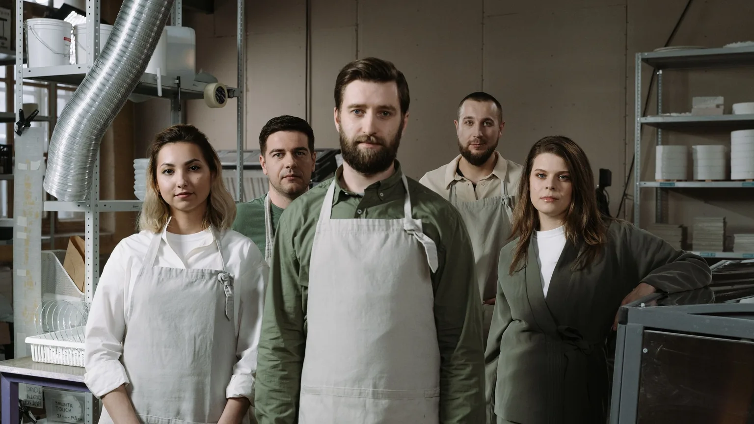 Members of a makers' guild in aprons standing together in their workshop